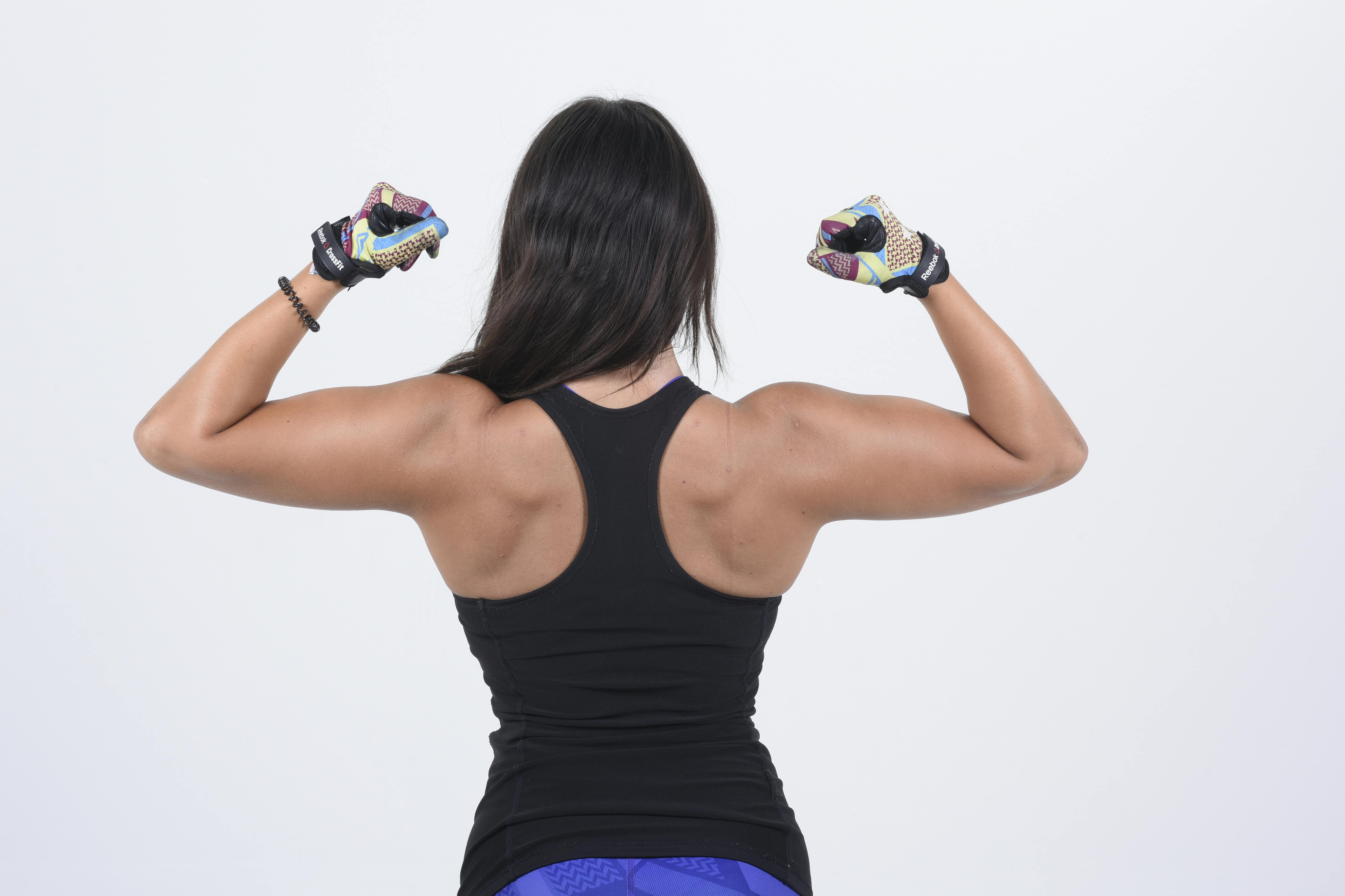 Young woman showing her strength and fitness in a studio setting.